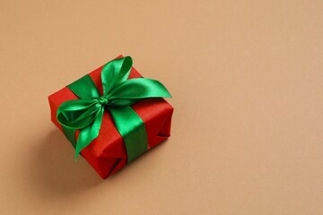 Beautiful gift box tied with bow on color background 
