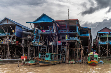 The colorful village of Kampong Phluk with houses on stilts, fishing boat and fishing nets near...