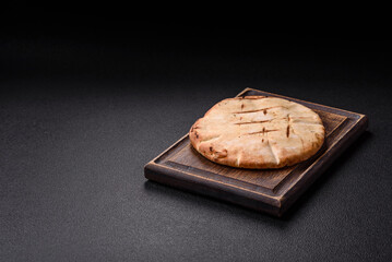 Round flatbread or pita with cheese, herbs, salt and spices