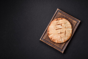 Round flatbread or pita with cheese, herbs, salt and spices