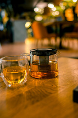 A cup and a teapot on a table in a restaurant. The concept of tea