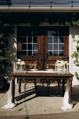 A cozy corner for lovers: a stylish table setting with crystal glasses under an arch of green grapes.