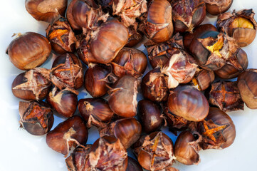 Roasted chestnuts. Chestnut season. Split chestnuts so they don't explode when roasting, and roast in a pan or oven until soft.