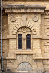 Fototapeta premium Windows and decoration details of a yellow brick wall, vintage building facade