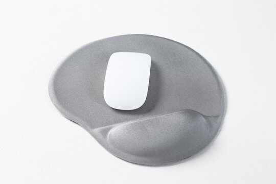 Mouse and mousepad with arm rest on white table, closeup