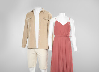 Female and male mannequins with stylish outfits on light grey background
