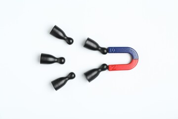 Magnet attracting human figures on white background, flat lay