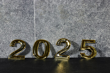 golden  numbers 2025 two thousand twenty five new year near a marble gray wall 