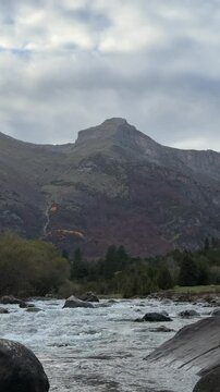 R&iacute;o en un paisaje oto&ntilde;al con monta&ntilde;as nevadas bajo un cielo nublado en el Parque Nacional de Ordesa