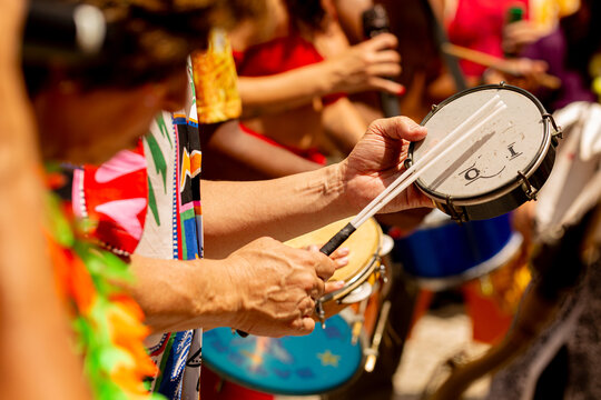 M&atilde;os tocando tamborim, pandeiro e tambor no Carnaval de Rua de S&atilde;o Paulo. 