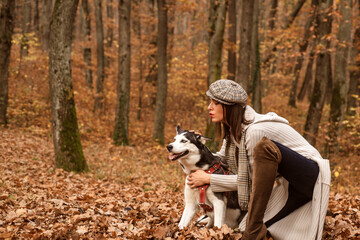 Autumn walk and petting concept. Best friend. Girl enjoy walk with husky dog. Woman with her dog chose a great place to stroll because the paints of autumn forest makes some mood feeling.