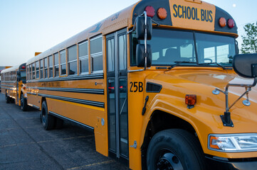 two big yellow schoolbusses on a parking lot in marquette wisconsin