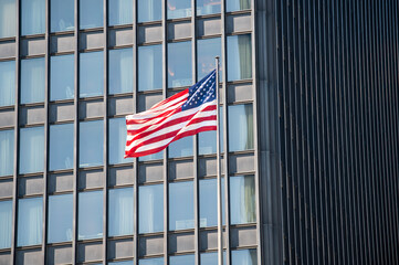 view of an amercian flag in front of a chicago skycraper