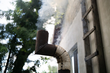 Smoke from an old rusty pipe in the backyard