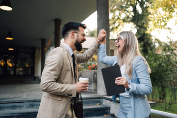 Two excited business people celebrating success outdoors