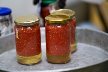 Glass cans with tomato sauce boiling. Preserving tomato sauce for winter. Canned food