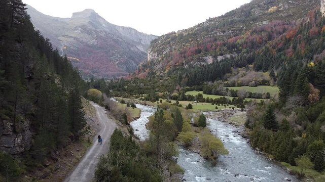 Vuelo de dron siguiendo un r&iacute;o con paisaje monta&ntilde;oso y excursionistas en el Parque Nacional de Ordesa