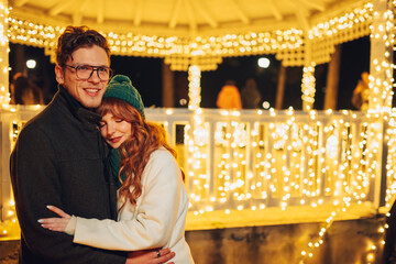 Romantic couple hugging on city street on new year's eve.