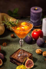 Elegant fall cocktail decorated with rosemary in martini glass