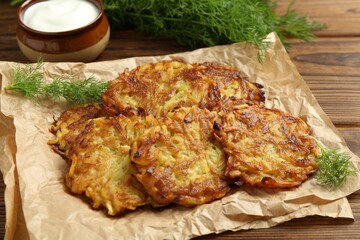 Delicious potato pancakes served on wooden table, closeup