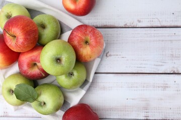 Different whole ripe apples on white wooden table, flat lay. Space for text
