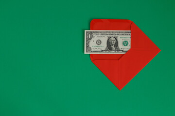 The envelope contains a one-dollar bill. It is in a red envelope on a green background.
