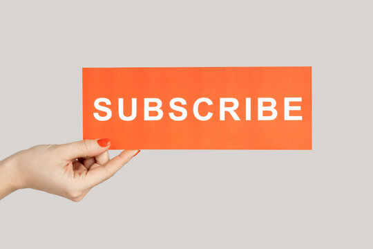 Woman hand showing red card with subscribe inscription, blogger inviting new followers.