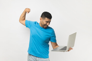 Angry aggressive unshaven man working on notebook, expressing anger, wants to knock display.