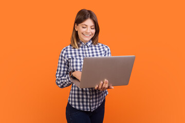 Fototapeta premium Successful smiling woman typing on laptop keyboard, browsing internet, making presentation