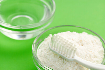 Toothbrush, baking soda and water for oral hygiene - Green background.