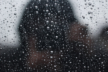Raindrops on the window. Small drops are collected in a heap