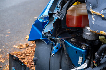 heavily damaged car with crumpled hood and exposed engine, aftermath collision, crash scene, with...