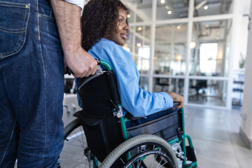 Obraz premium Woman in wheelchair managing her job despite her disability posing in modern office