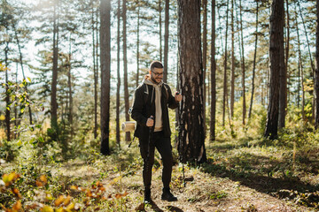 Young caucasian man hiking or trekking through the forest	
