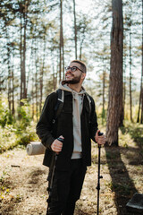 Young caucasian man hiking or trekking through the forest	