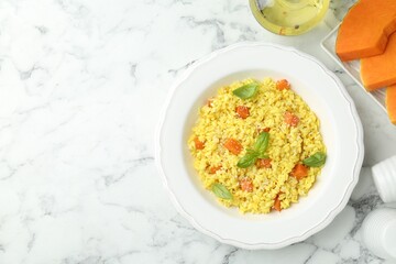 Delicious pumpkin risotto on white marble table, flat lay. Space for text