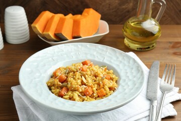 Delicious pumpkin risotto served on wooden table, closeup