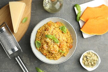 Delicious pumpkin risotto on grey table, flat lay