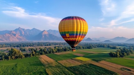 Naklejka premium Vibrant Hot Air Balloon Over Scenic Landscape