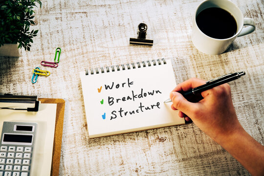 There is notebook with the word Work Breakdown Structure. It is as an eye-catching image.