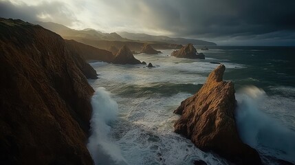 Obraz premium Dramatic sunset over rocky coastline with crashing waves.