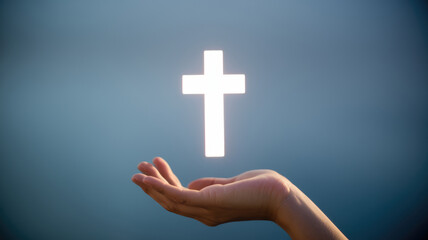 Fototapeta premium A hand holding a white cross. Concept of peace and hope