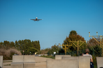 Airplane landing at El Prat airport with the city skyline in the background of Barcelona