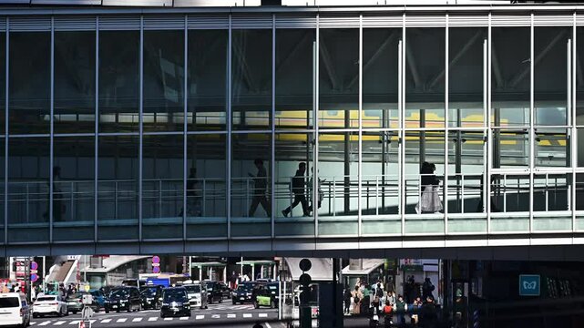 People coming and going at Shibuya Station, trains coming into the station, taxis and cars at the intersection, Shibuya, Tokyo, Japan / 渋谷駅の人の往来　電車が駅に入ってくる　交差点のタクシーと車　渋谷　東京　日本