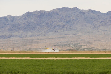 Crop duster flying over a field