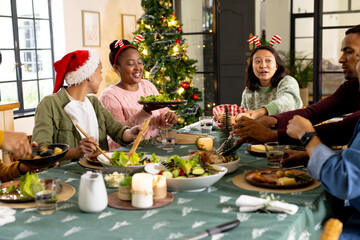 Gathered for christmas dinner, multiracial friends, at home