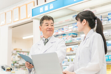 薬局で一緒に働く薬剤師・調剤師の男女
