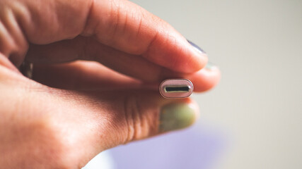 A hand holding usb plug c type close up minimalist technology