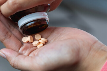Women hands holding pills of vitamin or supplement. Healthcare and medical concept