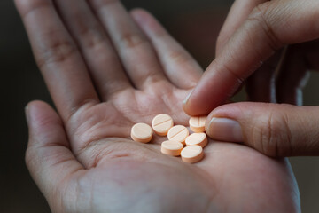 Women hands holding pills of vitamin or supplement. Healthcare and medical concept